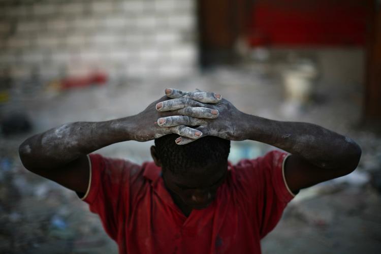 En formodet røver holder hænderne oven på hovedet. Politiet i Haiti og internatinale redningsstyrker forsøger at begrænser kriminaliteten, der blomstrer i det kaos, der har efterfulgt jordskælvet. 