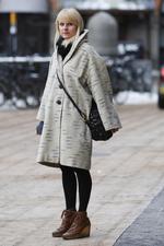 Rikke Kjær (33 år). Modeeksperten siger: »Flot frakke i et oversize-look. Snørestøvlerne med plateau ser man mange af denne vinter. Det er ret fint, at de er i brunt læder. Det bryder det grå/ sorte look og skaber kontrast«. 