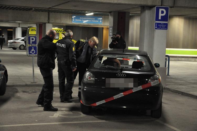 SKYDERI. Betjente ved den bil, som skudoffers venner ankom til hospitalet i. Bilen har knust bagrude, men ødelæggelsen stammer ifølge politiet ikke fra et skud. 