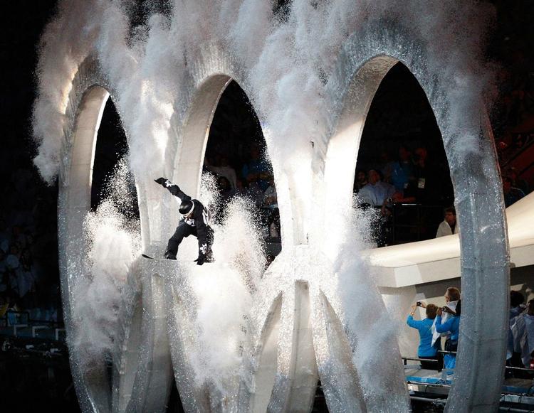 En snowboarder hopper gennem de olympiske ringe under OL's åbningsceremoni. 