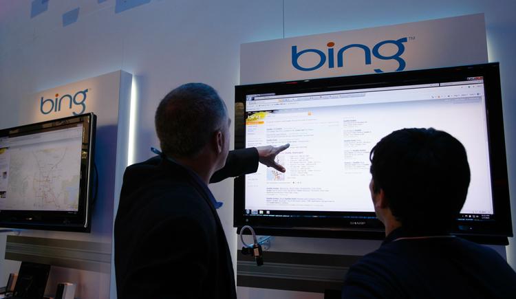 Gæster ved en it-messe i Las Vegas har fundet vej til Microsofts område, hvor de kigger på 'Bing'. 