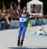 Guld. Jevgeni Ustjugov rækker armene i vejret efter han har krydset målstregen. 