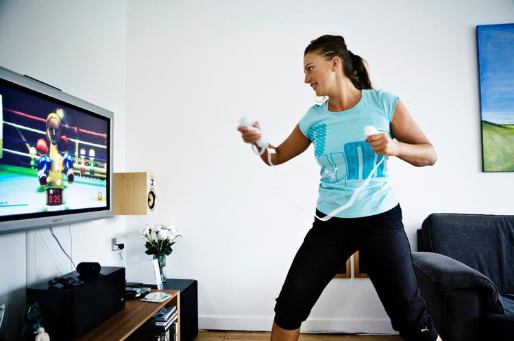 Med Wii-controlleren i hånden demonstrerer fitnesseksperten Lotte Pårup boksning med sig selv  foran fladskærmen. Nu har Wii-sportsspillene også fundet vej ud i skolernes idrætstimer. Arkiv 