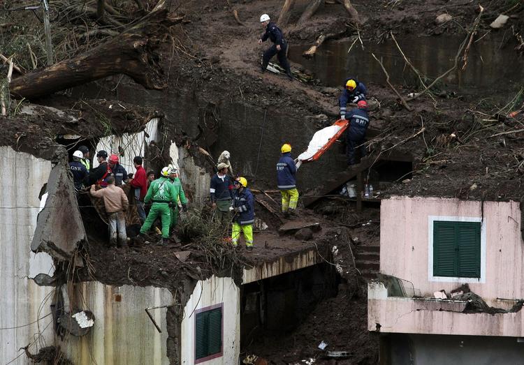 mudderskred. Redningsarbejdere bærer et lig ned ad bakkerne i landsbyen Santo Antonio på Madeira. 