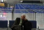 aflysninger. En passager tager sig en lur i den nærmest mennesketomme lufthavn i Athen, hvor strejken har stoppet alle flyvninger. 