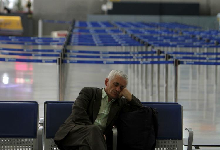 aflysninger. En passager tager sig en lur i den nærmest mennesketomme lufthavn i Athen, hvor strejken har stoppet alle flyvninger. 