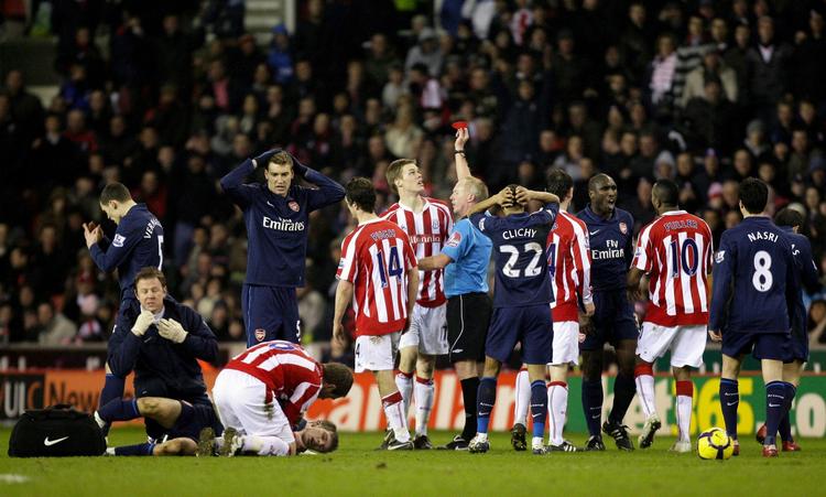 smerte. Mens Aron Ramsey vrider sig i smerte bliver Ryan Shawcross udvist af Peter Walton. 