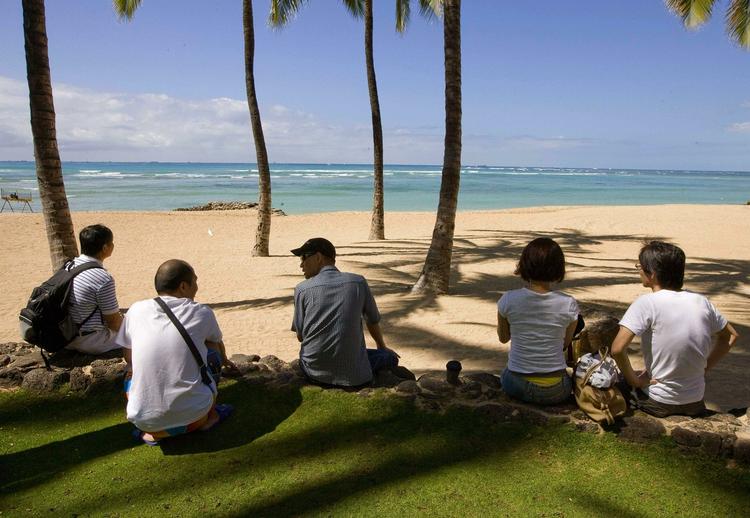 Ventetid. Der var udsendt tsunamiadvarsler på Hawaii, men flere turister satte sig alligevel godt til rette på stranden og ventede på bølgerne. Her er vi på Waikiki Beach i Honolulu. 