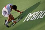 udmattet. En glad Novzak Djokovic synker sammen efter at have vundet den regnvejrsafbrudte finale i Dubai. 