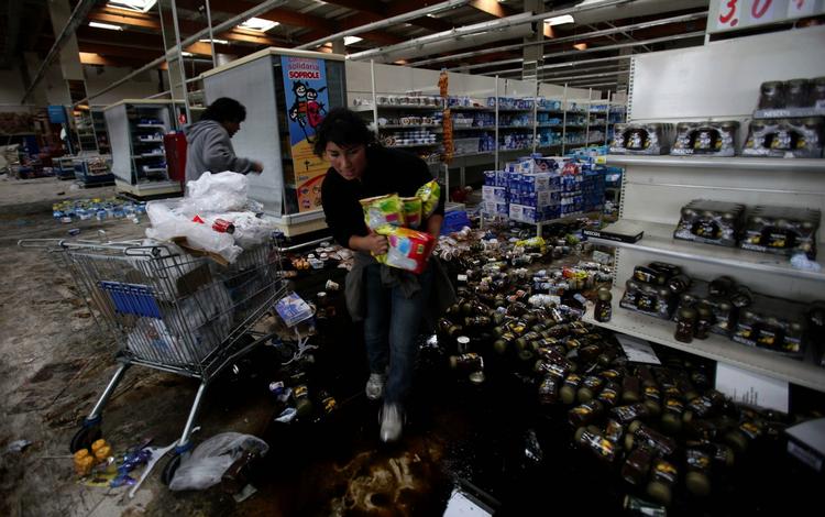 PLYNDRINGER. Sultne chilenere invaderer supermarkeder i landets næststørste by, efter et voldsomt jordskælv ramte landet i går. 