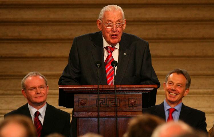 Forsoning. Billedet er fra det nordirske parlament i maj 2008, hvor Ian Paisley er på talerstolen, flankeret af Martin McGuiness (tv) og daværende premierminister Tony Blair (th) 