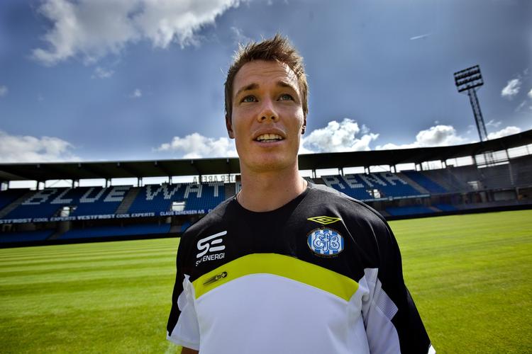 revner. Esbjerg-spiller Jesper Jørgensen foran det funklende nyrenoverede stadion 'Blue Water Arena' i Esbjerg. Nu er betonen begyndt at revne og et stort stykke er faldet fra en af de bærende søjler. Arkivfoto. 
