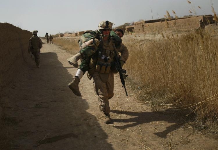 Krig. En amerikansk soldat bærer en afghansk kammerat væk , efter at han er blevet såret under de hårde kampe om byen Marjah i februar. 