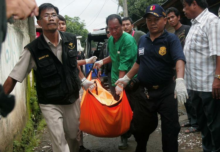 ANTITERRORAKTION. Indonesisk politi bærer skuddræbt mand væk efter aktion mod formodede terrorister. 