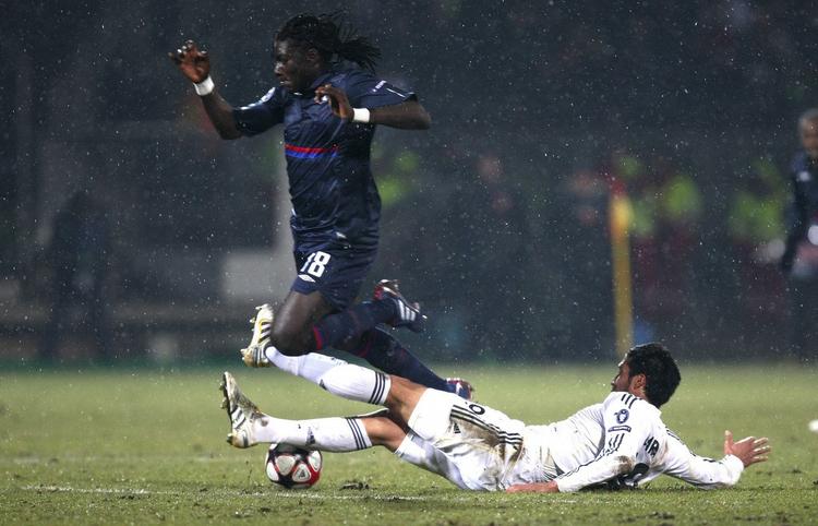 returkamp. Lyons Bafetimbi Gomis bliver fældet af Real Madrids Ezequiel Garay i klubbernes første opgør. Arkivfoto. 
