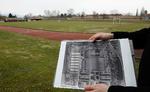 Begravelsesplads. Det østrigske forsvar har offentliggjort dette billede, hvor en mand holder et luftfoto taget af amerikanske piloter frem. På billedet kan man angiveligt se åbne massegrave, hvor der i dag er en fodboldbane, som man kan se det i baggrunden. 