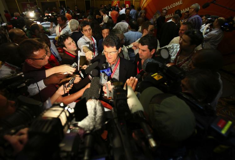 omsværmet. Englands træner Fabio Capello i midtpunktet for journalisternes spørgsmål ved en trænerkonference i Sydafrika i sidste måned. Arkivfoto. 