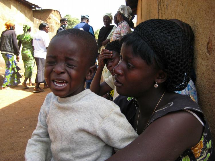 REIGIØS MASSAKRE. Mor trøster sin grædende søn i den nigerianske landsby, hvor 200 mistede livet i en massakre den 7. marts. 
