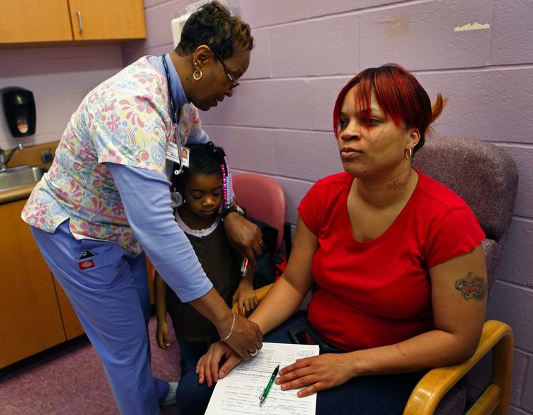 sundhedstjek. Sherri Stone får tjekket pulsen på et sundhedscenter i Cincinnati. Hun er en af de mange amerikanere, der får hjælp af sundhedsreformen. I dag tjener hun for meget til at være dækket af det offentlige og for lidt til at have råd til en privat forsikring. Datteren Kamaria, 4, er dog dækket af den statslige SCHIP-ordning til børn, der blev indført i 1997.        Foto: AP/The Cincinnati Enquirer, Carrie Cochran 