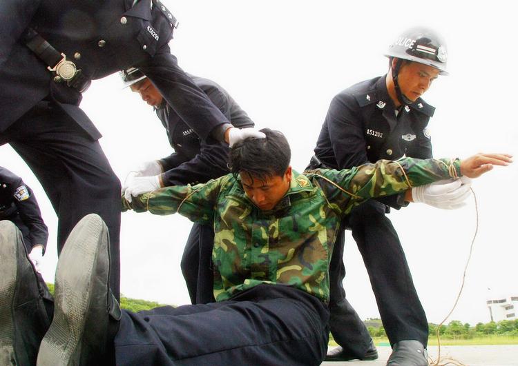Politiet i Nanning i det sydlige Kina øver sig i at binde en fange, der skal henrettes. Amnesty udfordrer det kinesiske styre til at offentliggøre antallet af henrettelser. 
