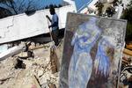 Ruinerne. En oprydningsarbejder har gravet et beskadiget maleri af den haitianske Harry Jacques Arijak ud af ruinerne. Jordskælvet har selvsagt ødelagt store mængder kunst. Foto: AP 