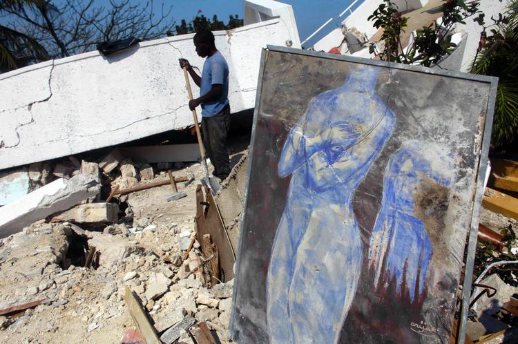 Ruinerne. En oprydningsarbejder har gravet et beskadiget maleri af den haitianske Harry Jacques Arijak ud af ruinerne. Jordskælvet har selvsagt ødelagt store mængder kunst. Foto: AP 