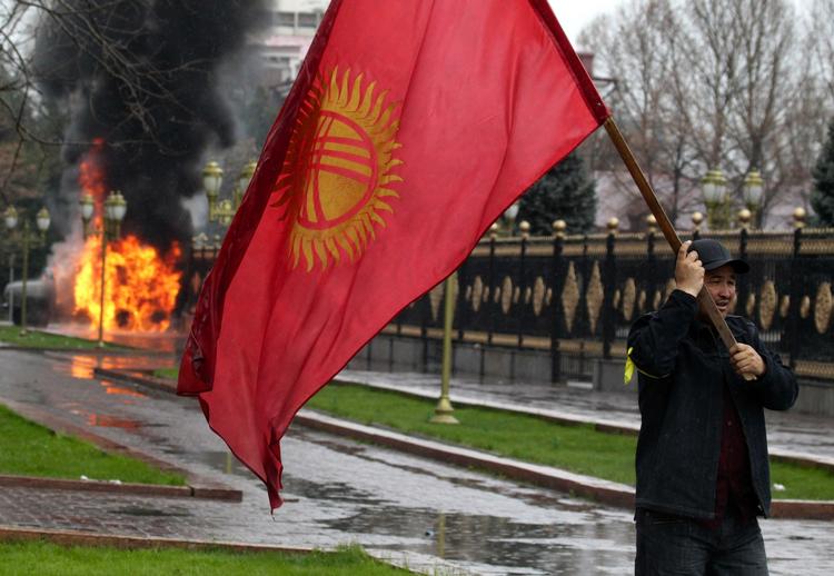 OPRØR. Demonstrant med det kirgisiske flag under kampene i hovedstaden Bishkek i går. De sendte præsidenten på flugt og har nu bragt oppositionen til magten i et forsøg på at standse korruotionen i landet. 