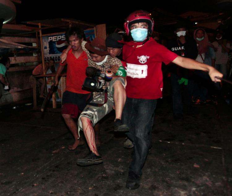 Mindst 200 mennesker er såret under voldsomme gadekampe i Bangkok. Her er det gået ud over en fotograf. 