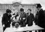 JUBILÆUM. Med vanlig sans for virkningen af provokation valgte Malcolm McLaren (nr. 3 fra højre), at Sex Pistols skulle udgive sin anden single 'God Save the Queen' samtidig med dronning Elizabeths 25-års jubilæum på tronen i 1977. Her skriver bandet kontrakten under foran Buckingham Palace. Manageren blev selv anholdt, da Sex Pistols spillede sangen live på en båd på Themsen ud for det britiske parlament. Men strategien virkede - singlen indtog 1. pladsen. Arkivfoto: AP 