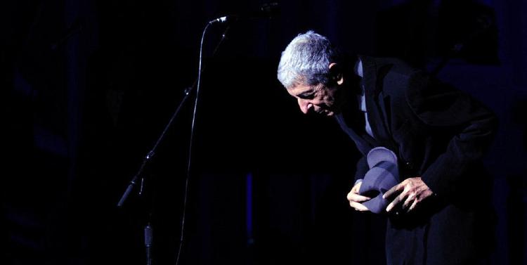 Under sin stilfulde hat, som kaster nådige skygger over ansigtet, er Leonard Cohen, stadig en forførende fortolker af sine egne visdomsord og smukt, optimistiske melodier med en dyb stemme, der er mere end  intakt. Her fra koncerten i Toronto 6. juni. Foto: Aaron Harris/AP. 