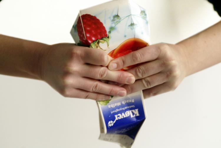 Man skal mase godt til for at få resteerne ud af en yoghurtkarton. 