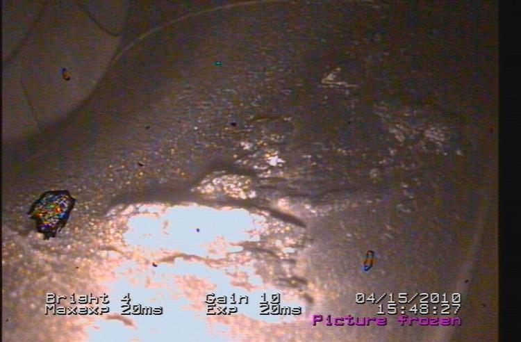 The combustion chamber in an F-18 engine. The lighter, light-reflecting areas are deposits of ash on the inside surface of the combustor. 