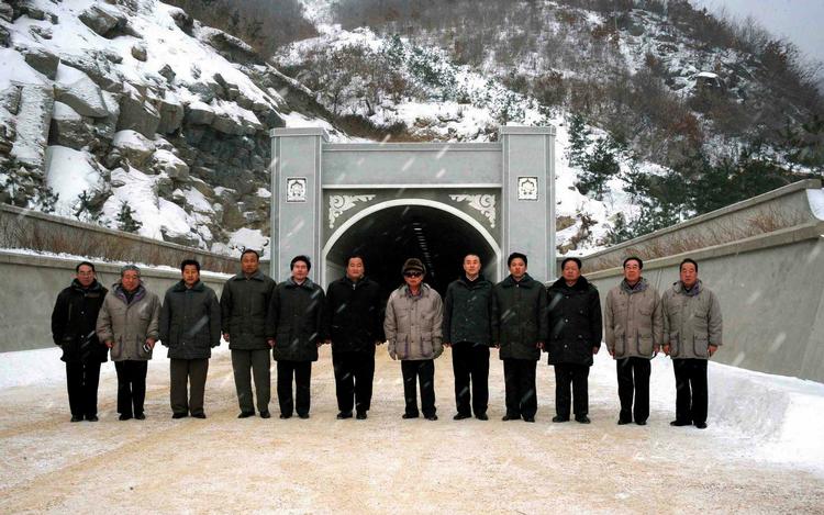 NORDKOREA. Nordkorea har ifølge sydkoreanerne sendt soldater mod syd for at dræbe afhopper. Her ses Nordkoreas diktator Kim Jong Il (iført lys jakke i midten af gruppen) ved officelt foto fra nyt vejbyggeri nær hovedstaden Pyongyang. 