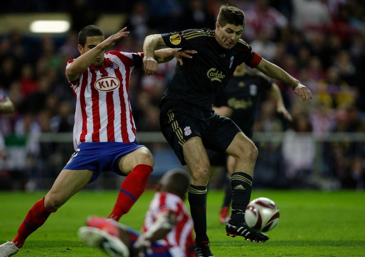 dominans. Liverpools Steven Gerrard (th) tackles af Atletico Madrids Alvaro Dominguez under kampen i Spanien, hvor spanierne sad på det meste af spillet. 