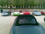 En Mercedes 300 SL holder øje med en stribe Porsche-biler af forskellige årgange. 