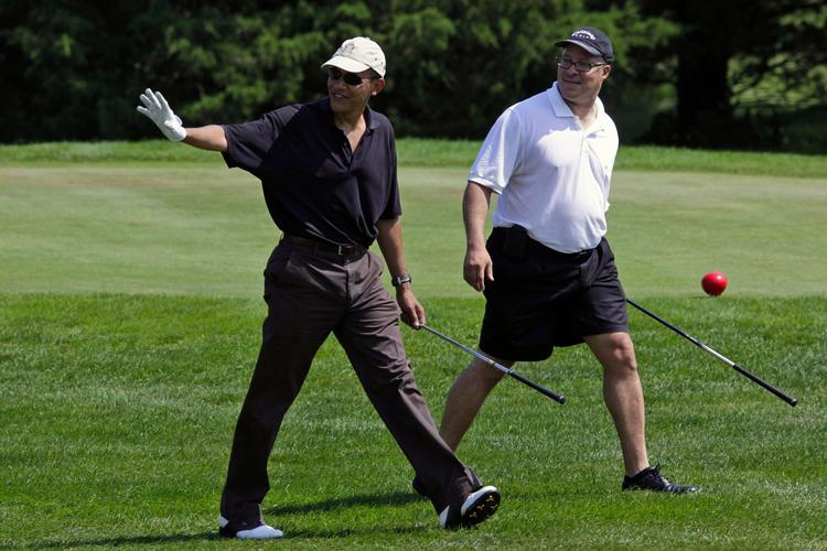 DAV. Præsident Barack Obama hilser på, mens han traver gennem en 18-hullers golfbane sammen med vennen lægen Eric Whitaker. 