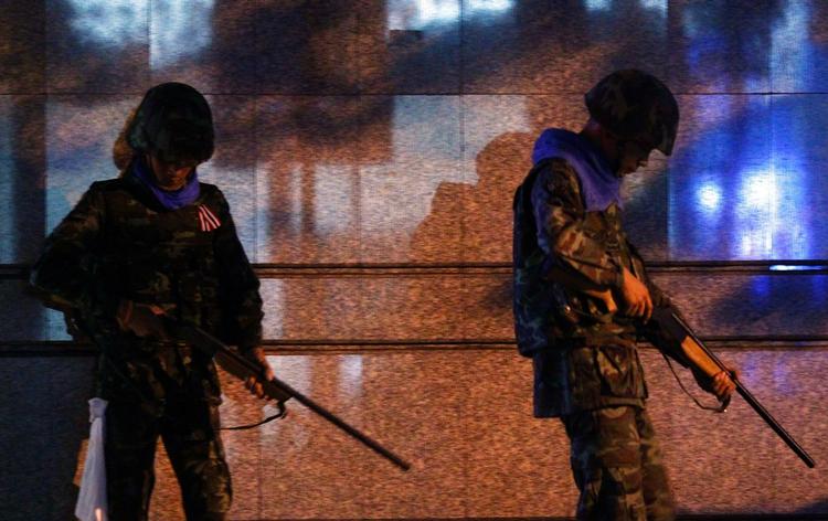 Udstationeret. Thailandske soldater bevogter en handelsvej i Bangkok. Et andet sted i byen har soldater affyret varselsskud. 