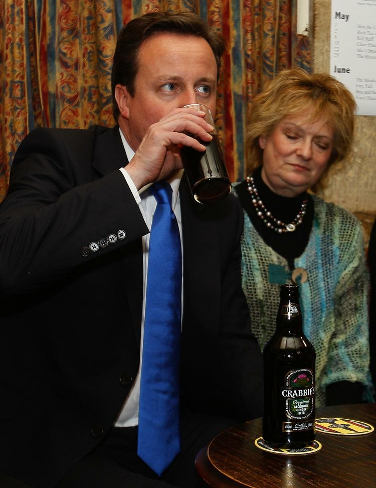 Spænding. David Cameron får lidt at drikke, mens han ser stemmetallene tikke ind. 