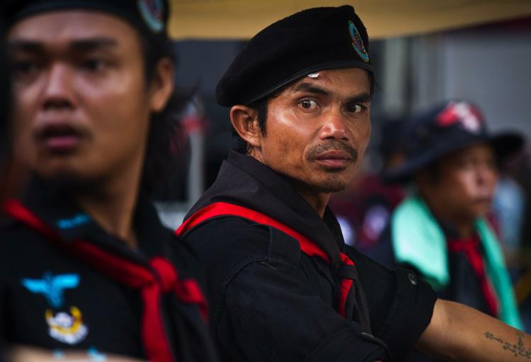 Spændinger ulmer i Bangkok. Her optræder en regeringskritisk demonstrant som sikkerhedsvagt. 