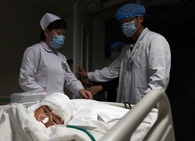 Overlevende. Et af de overlevende børn køres til yderligere  behandling på hospitalet i Hanzhong i Kinas nordlige Shaanxi provins. 