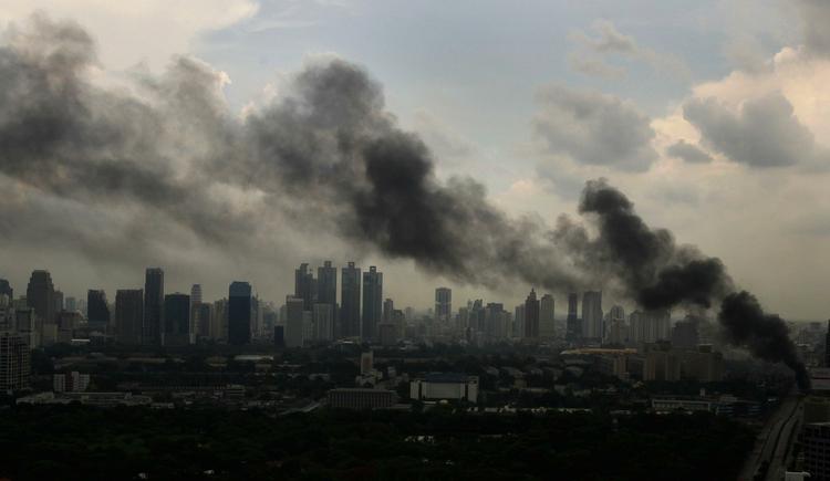 Skyline. Tung røg over Bangkoks skyline fra de mange bildæk, som de rødtrøjede demonstranter sætter ild til. 