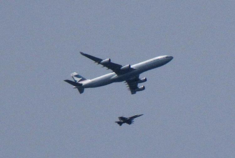 Beskyttet. Passagerflyet med et jagerfly ved sin side. 