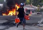 Hamstring. En demonstrant bærer dunke med fortynder i det centrale Bangkok. 