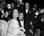 Spotlys. De var skamløst rige, Elizabeth Taylor og hendes producermand Mike Todd, indtil han styrtede i et fly og efterlod en utrøstelig enke. Der gik op til flere måneder, før hun valgte crooneren Eddie Fisher til at besmykke sin seng. Her ses hun med Todd i Cannes 1957, som altid omgivet af paparazzi. Foto: AP 