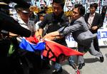 Sydkoreanske demonstranter kæmper mod politiet, da de prøver at sætte ild til det nordkoreanske flag nær den amerikanske ambassade i den sydkoreanske hovedstad Seoul. 