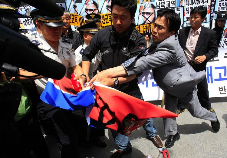 Sydkoreanske demonstranter kæmper mod politiet, da de prøver at sætte ild til det nordkoreanske flag nær den amerikanske ambassade i den sydkoreanske hovedstad Seoul. 