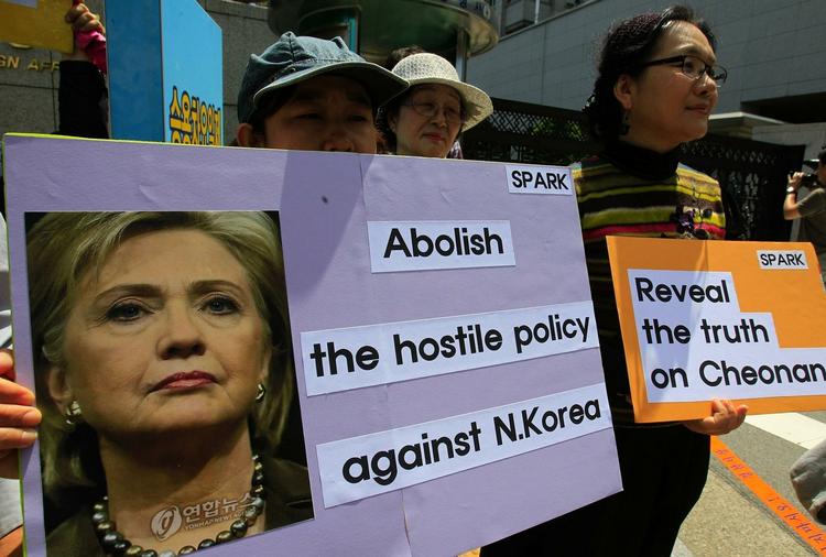 Demonstranter holder billeder af Hillary Clinton i forbindelse med hendes besøg i Seoul i dag. 
