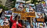 Sydkoreanske demonstranter råber slagord, mens de holder billeder af den nordkoreanske leder Kim Jong II. 