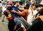 SKYDERI. Kvæstet bæres væk af redningsmandskab efter dagens angreb mod moskeer i Lahore i Pakistan. 