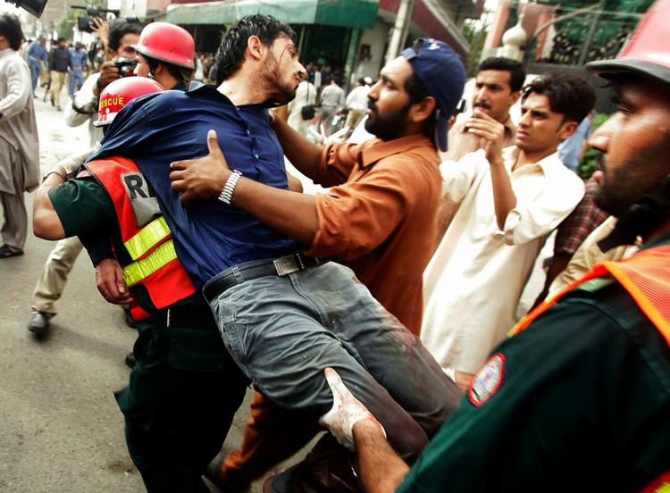 SKYDERI. Kvæstet bæres væk af redningsmandskab efter dagens angreb mod moskeer i Lahore i Pakistan. 